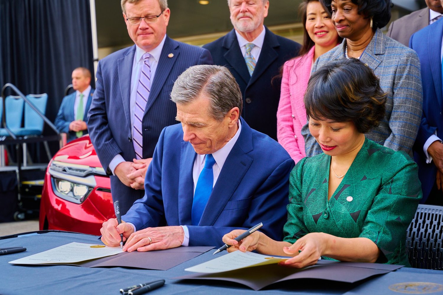 N.C. Gov. Roy Cooper (left) and Vingroup's vice chairman and CEO of VinFast Global, Le Thi Thu Thuy, sign a memorandum of understanding that brings VinFast — and with it, 7,500 jobs at N.C.'s first automotive plant — to Chatham County.